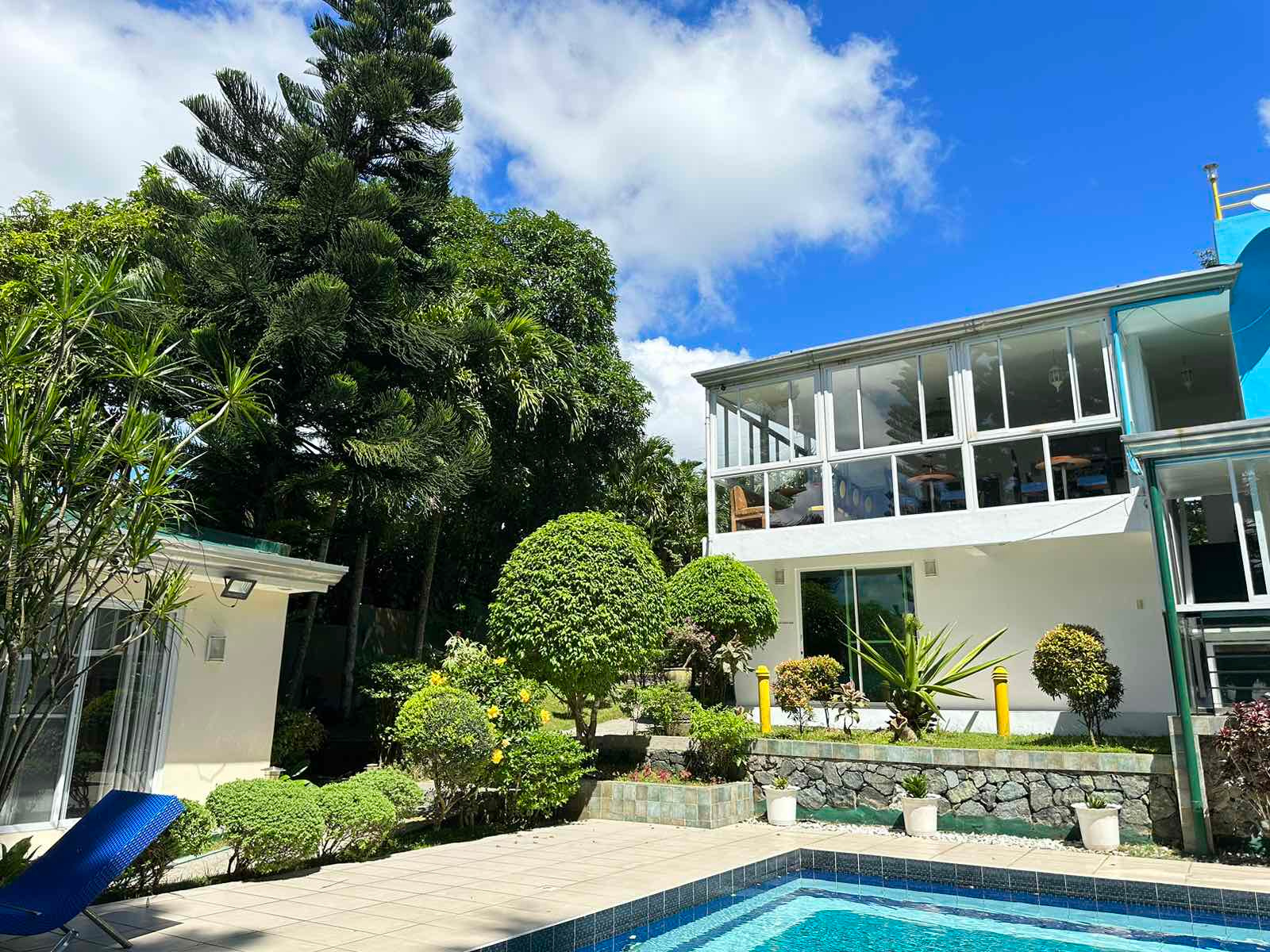A private resort in Cavite with a swimming pool and lush green landscaping, offering a relaxing getaway for guests.
