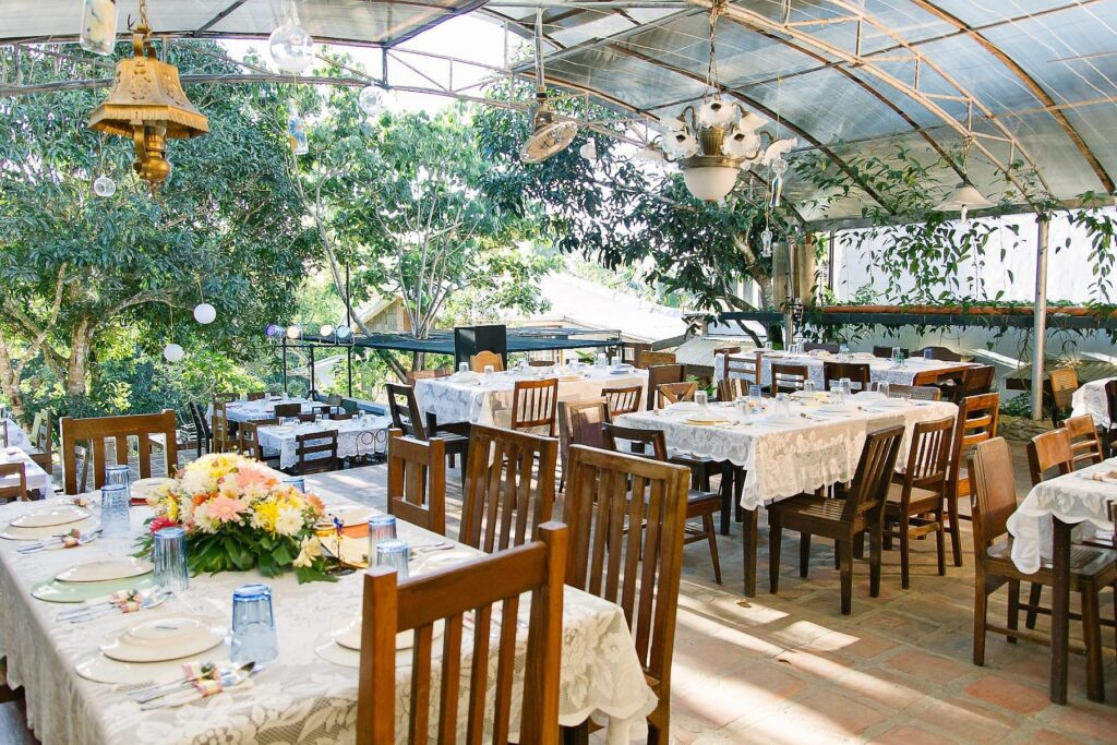 A cozy outdoor dining area in Cavite with wooden tables, floral centerpieces, and a nature-inspired ambiance, ideal for casual gatherings.