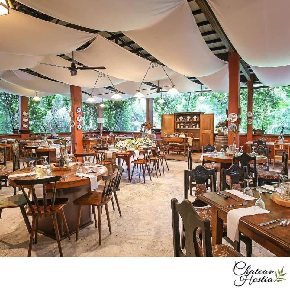 A charming rustic garden restaurant in Cavite with wooden furniture, ambient lighting, and lush greenery, perfect for intimate dining experiences.