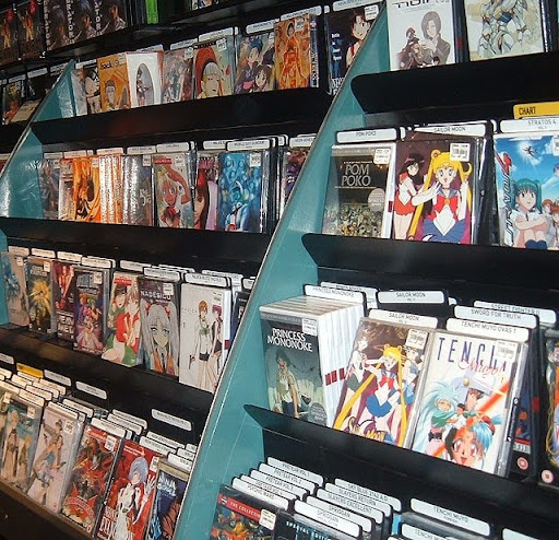 Shelves filled with various anime DVDs and Blu-rays in a Japanese pop culture store.